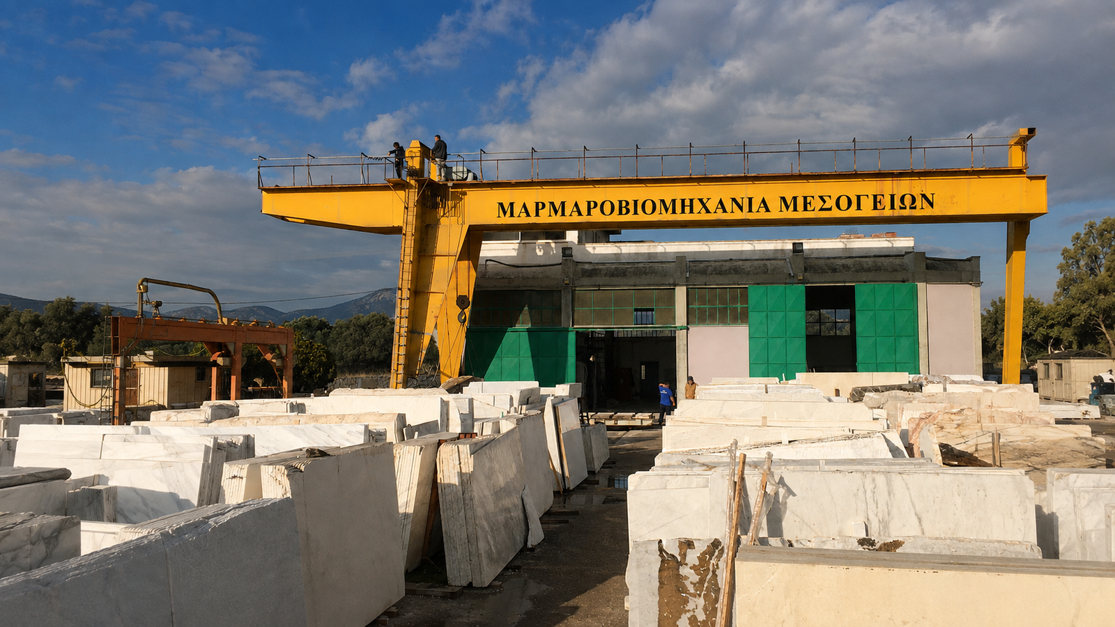 Εξωτερικός χώρος της Μαρμαροβιομηχανίας Μεσογείων με πλάκες μαρμάρου και την κίτρινη γερανογέφυρα